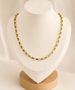 Cadena de acero quirúrgico dorado tipo Forçat Lungo de 70 cm, exhibida sobre busto blanco con fondo neutro cálido.