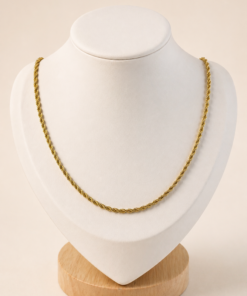 Cadena de acero quirúrgico dorado tipo lazo de 50 cm, exhibida sobre busto blanco con fondo neutro cálido.