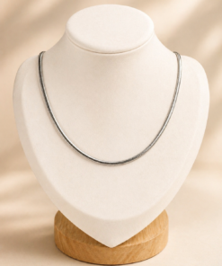 Cadena de acero quirúrgico tipo Snake Bombé de 55 cm exhibida sobre busto blanco con fondo neutro cálido.