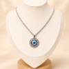 Cadena en acero quirúrgico con dije circular de ojo turco en tonos azul, blanco y negro.