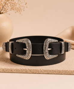 Cinto negro de doble hebilla tejana plateada sobre fondo neutro, estilo western moderno para mujer