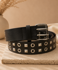 Cinto de 4 cm con tachas y ojalillos metálicos sobre fondo beige elegante, estilo urbano y moderno
