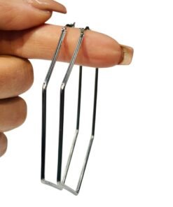 mano exhibiendo caravana aro con forma hexagonal de acero quierurgico