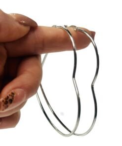 mano exhibiendo un par de aros con forma de corazon de acero quirurgico