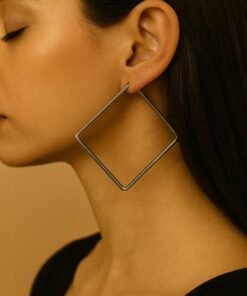 modelo exhibiendo caravanas en forma cuadrada de acero quirurgico