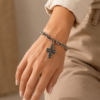 Pulsera de acero quirúrgico con cadena de eslabones y dije decorativo en acabado brillante en mano de modelo