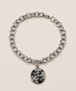 Pulsera de acero quirúrgico con cadena de eslabones y dije decorativo en acabado brillante. Flores