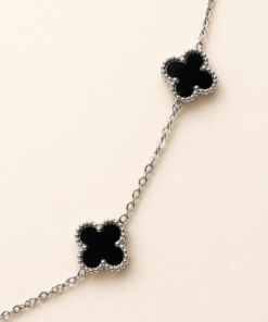 Cadena de acero quirúrgico plateado con detalles de trébol negro de estilo elegante y delicado