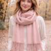 Modelo luciendo bufandón de tejido suave con flecos, ideal para looks abrigados de otoño e invierno, color rosa