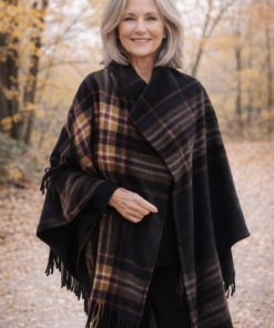 Modelo luciendo ruana polar escocesa negra con cuadros en tonos bordo, camel y beige