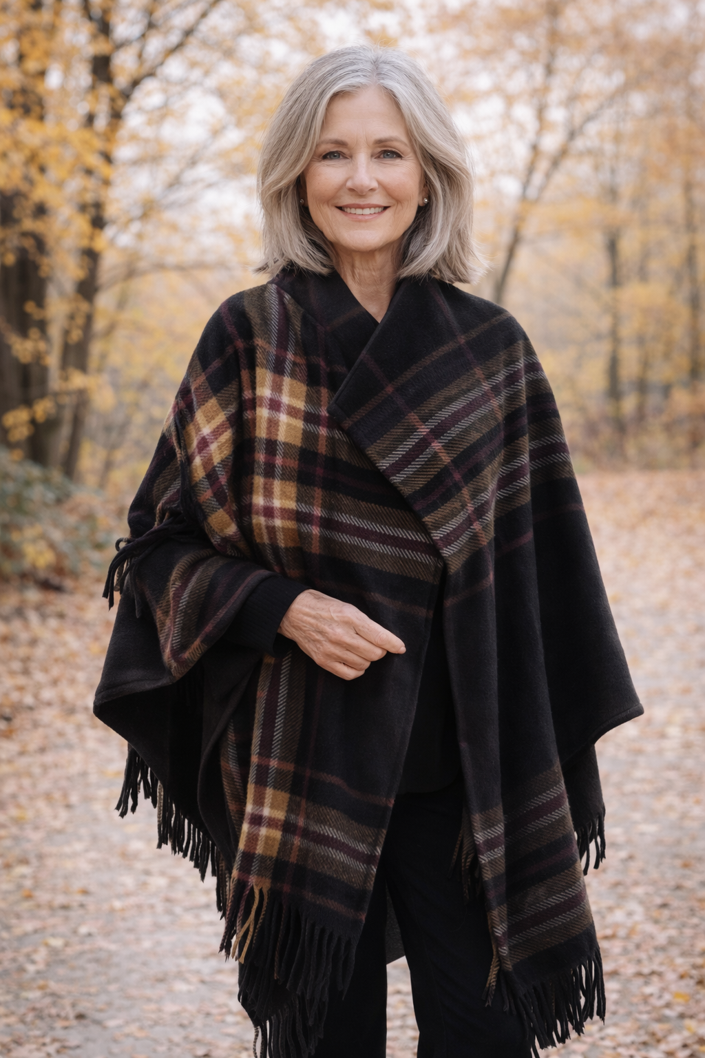 Modelo luciendo ruana polar escocesa negra con cuadros en tonos bordo, camel y beige