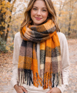 Modelo con Bufandón de tejido suave con flecos, ideal para looks abrigados de otoño e invierno, rayado naranja y negro