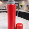Termo 750ml con manija y pico cebador rojo sobre mesada de cocina elegane