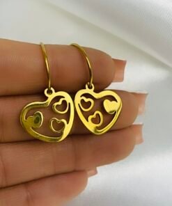 mano mostrando caravana corazon colgante de acero dorado