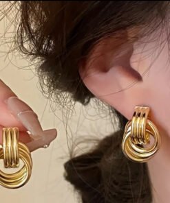 mujer luciendo caravanas doradas en bijou nudo