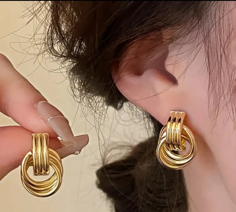 mujer luciendo caravanas doradas en bijou nudo