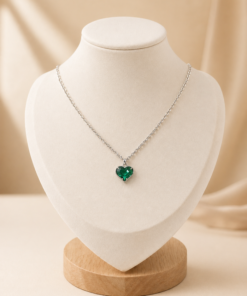 Cadena de acero con dije de cristal en forma de corazón verde.