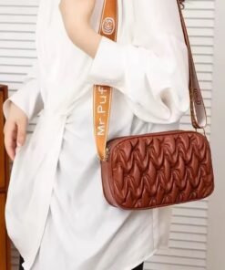 mujer modelando morral puffy color whisky