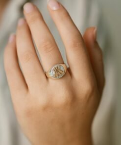 mano exhibiendo anillo plafa con aplique en oro de abeja