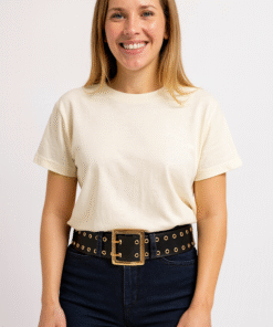 Mujer vestida casual con jeans oscuros y remara blanca, luciendo cinto ancho con 2 hileras de ojalillos dorados