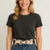 Mujer vestida casual con jean y remera negra, luciendo cinto cow print vaca con tachas