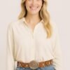 mujer rubia vestida casual con jean y camisa blanca luciendo cinto Boho fino con chapón plateado color marrón