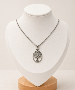 Conjunto en plata 925 con cadena fina y dije ovalado calado Árbol de la Vida, presentado sobre busto blanco con fondo neutro cálido.