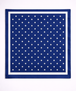 Pañuelo de seda con estampado de lunares y borde definido azul, sobre fondo neutro claro