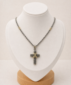 Cadena plata 925 con double de oro y dije de cruz panther con detalles en oro presentada sobre busto blanco con fondo neutro cálido.
