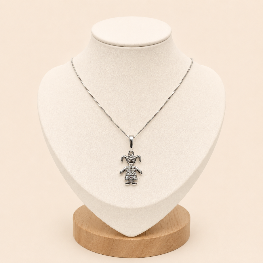 Conjunto de plata 925 con cadena fina y dije de niña con circonias brillantes sobre busto blanco elegante.