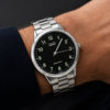Reloj Q&Q de hombre con malla metálica, fondo negro y números iluminator