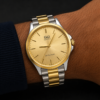 Mano modelo luciendo reloj metal hombre combinado esfera dorado