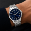 Reloj Q&Q de hombre con malla metálica, fondo azul y números iluminator