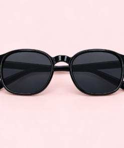 Lente de sol unisex NOA redondeado con armazón negra , cristales negros y detalles metálicos dorados